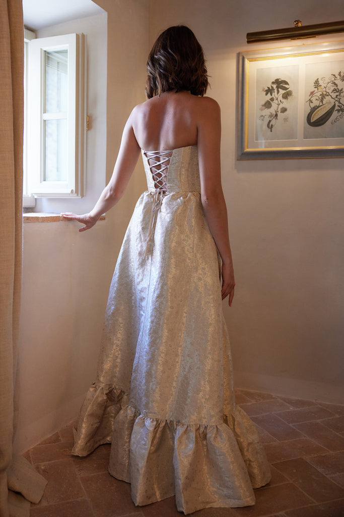 photo of model from the back in the charlotte dress in taupe duchess