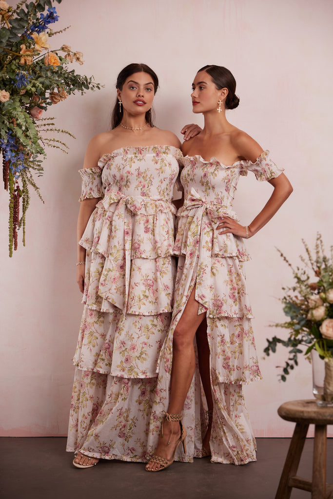 two models both wearing the angelina dress in pink rose print. left model showing full front view. right model showing full side view.