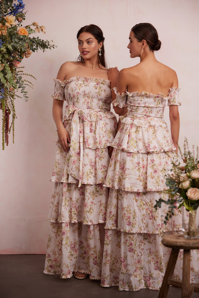 two models both wearing the angelina dress in pink rose print. left model showing full front view. right model showing full back view.