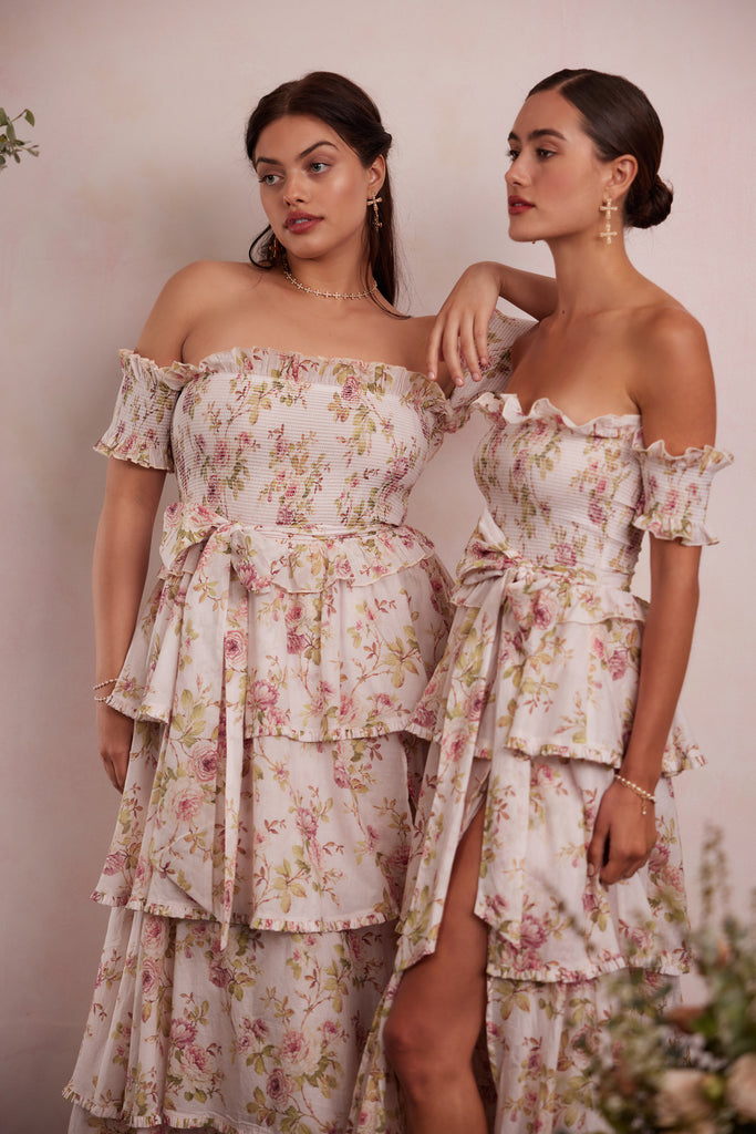 two models both wearing the angelina dress in pink rose print. left model showing full front view. right model showing full side view.