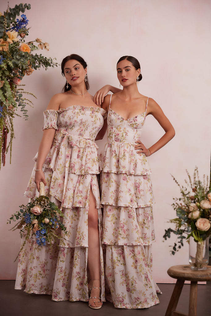 two models wearing dresses in pink rose print. right model showing full front view wearing angelina dress in pink rose print. right model showing full front view wearing caterina dress in pink rose print.