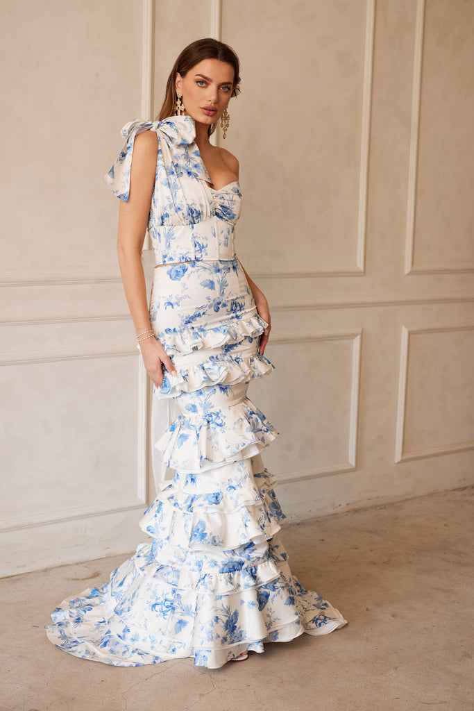 Full front and side view of model wearing The Barcelona set in Provencal Blue Floral with positano earrings. Model standing in front of white wall.