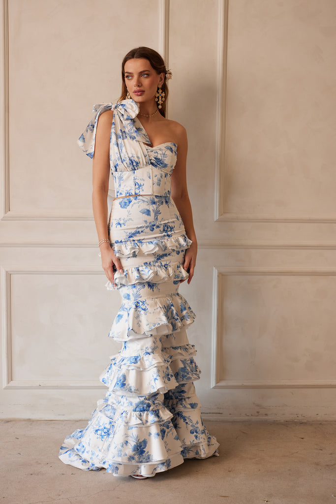 Full front view of model wearing The Barcelona set in Provencal Blue Floral with positano earrings. Model standing in front of white wall.