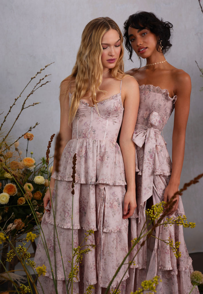 two models wearing blush bouquet dresses. left model wearing caterina dress in blush bouquet, front view. right model wearing angelina dress with sleeves detatched, side view.
